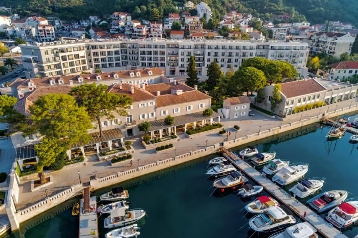Oro nuotrauka viešbučio prie marinos su laivais ir žaliais kalnais. - Oro nuotrauka viešbučio prie marinos su laivais ir žaliais kalnais.